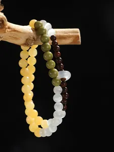 Primer plano de una pulsera de cuentas de doble capa con sándalo y piedra de ojo de gato