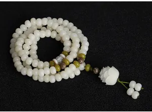 Detailed view of natural white Bodhi root 108 mala beads with a hand-carved lotus pendant.
