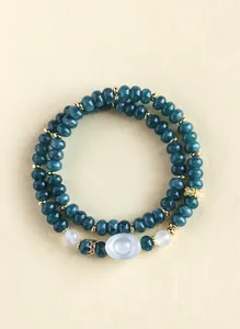 Top view detail of a double-strand teal chalcedony bracelet with gold spacers