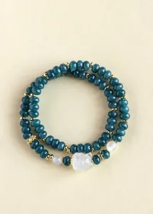 Detailed view of teal beaded double-strand bracelet with a white carved fox charm