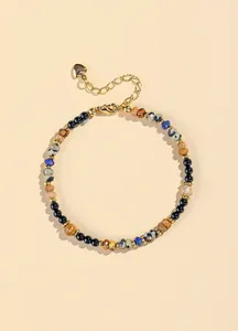 Detailed view of a 4mm natural lapis lazuli and black agate beaded bracelet with gold chain.