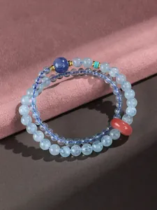 Detailed macro view of a double-strand aquamarine beaded bracelet with pink doughnut stone
