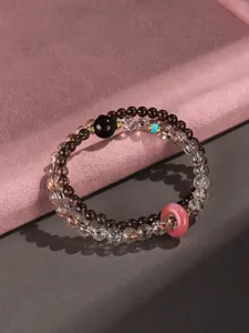 Detail view of double-layer beaded gemstone bracelet with pink ping'an kou charm.