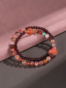 Detailed view of a double-layered beaded bracelet with strawberry quartz and garnet