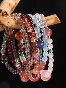 Macro view of colorful crystal beaded bracelets with doughnut charms on natural wood