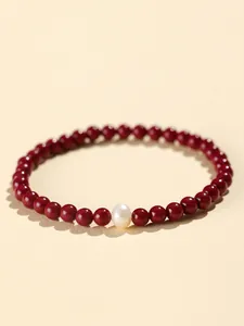 Detail of natural cinnabar bead bracelet featuring a single freshwater pearl focal point