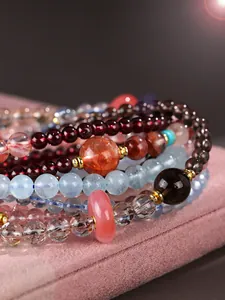 Macro view of multi-layered gemstone bracelets with aquamarine and strawberry quartz beads