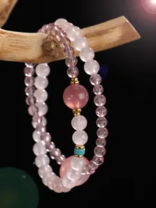 Close-up of pink rose quartz and strawberry quartz beaded bracelet with turquoise accent