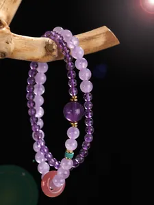 Close-up of double-layered amethyst beaded bracelet with a rose quartz donut charm