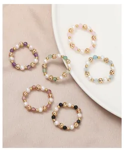 Detail view of various natural freshwater pearl and crystal elastic beaded rings.