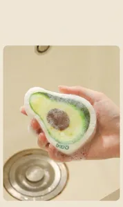 Gros plan d'une éponge en pulpe de bois en forme d'avocat créant une mousse riche