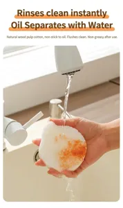 Gros plan d'une éponge en pâte de bois blanche rincée à l'eau pour les taches.
