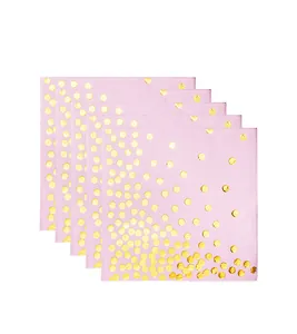 Detailed view of stack of pink disposable napkins with decorative gold foil polka dots.