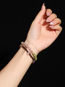 Detalle de pulsera de cuentas de ojo de gato rosa y sándalo con dije de hebilla Ping'an