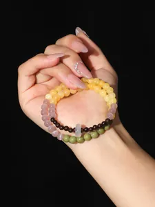 Pulsera de cuentas de doble capa con ojo de gato rosa y piedras Alashan en la mano.