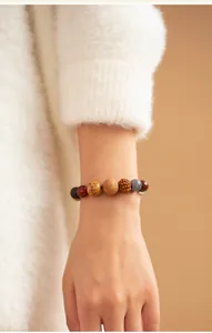 Close-up of traditional 18-seed Buddhist bracelet worn on wrist with white sweater