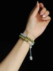 Detalle de una pulsera de cuentas de piedra Alashan y ojo de gato en una muñeca