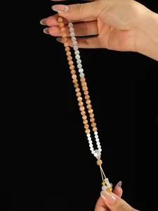 Detalle de una pulsera de doble vuelta con ojo de gato rosa y cuentas de sándalo