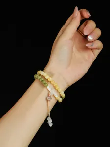 Primer plano de elegante pulsera de cuentas de dos capas con piedra ojo de gato