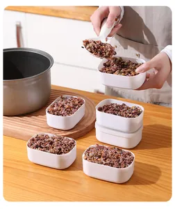 Close-up of small white containers filled with cooked multi-grain rice for portion control