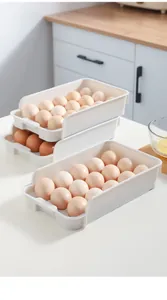 Vista detallada de contenedores apilables de plástico blanco para huevos en la cocina