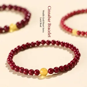 Traditional handmade red cinnabar bead bracelet with a central yellow lucky charm bead for women