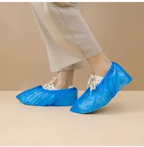 Langlebige blaue Einweg-Vlies-Überschuhe für den Innenschutz auf weißen Turnschuhen