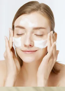 Close-up of rich white cleansing foam applied to a woman's face for skin care