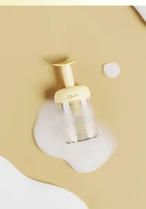 Detail shot of a manual foaming device with white soap bubbles on beige background
