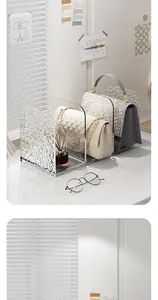 Detailed macro view of a clear acrylic desktop organizer holding designer bags on a desk.
