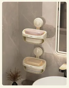 Close-up of a cream-colored double-layer suction cup soap dish on a marble bathroom wall