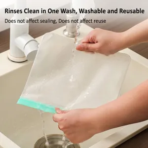 Reusable EVA food storage bag with green seal being washed under a kitchen faucet