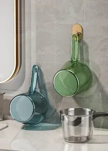 Vista detallada de cazos de agua transparentes de mango largo en un baño moderno y lujoso