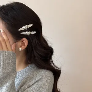 Vista detallada de elegantes pinzas para el cabello plateadas con forma de corazón