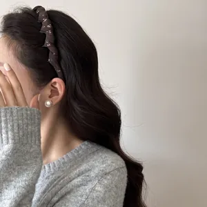Detailed side view of a vintage floral fabric wrapped headband worn by a female model