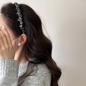 Close-up side view of a woman wearing a vintage floral fabric wrapped padded headband.