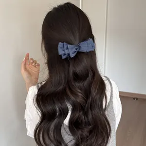 Vista dettagliata di un fermaglio per capelli a fiocco in denim blu su capelli lunghi
