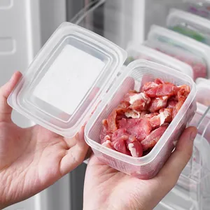 Contenitore in plastica alimentare per carne tenuto in mano all'interno del frigorifero