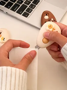 Dettaglio di un simpatico taglierino a cartone animato che taglia la carta, lama affilata