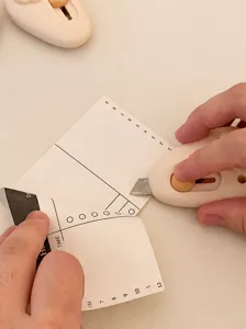 Primo piano di un mini taglierino a forma di nuvola che taglia la carta