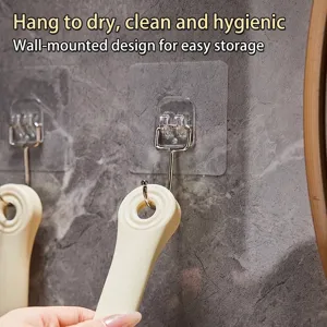 Minimalist long-handled cream bath brush hanging on a transparent wall hook for easy storage