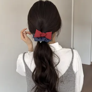 Vista posteriore di una modella con fiocco rosso ed elastico per capelli in denim