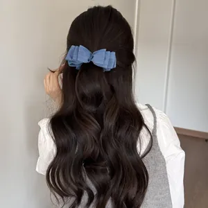 Dettaglio di un fermaglio per capelli a banana in denim su eleganti capelli mossi