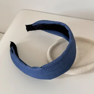 Vista dettagliata di un cerchietto largo in denim blu con fodera interna nera