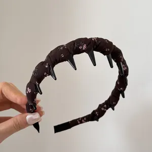 Detailed view of vintage floral fabric wrapped headband with black spikes