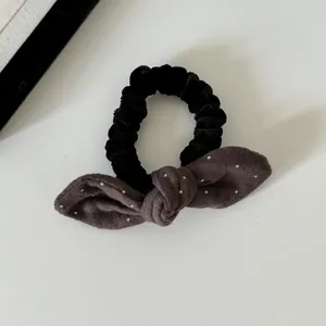 Close-up van een fluwelen scrunchie met een schattige stippen konijnenoren strik.