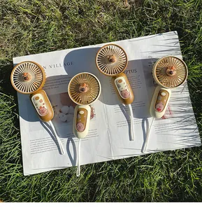 Close-up view of portable Capybara themed USB fans on a magazine in natural sunlight