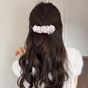 Détail d'une pince banane plissée de style coréen pour une coiffure en queue de cheval.