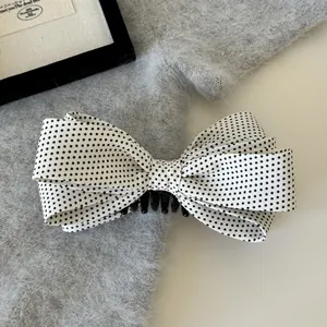 Detailansicht einer Bananenspange mit geschichtetem schwarz-weißem Polka-Dot-Schleifen