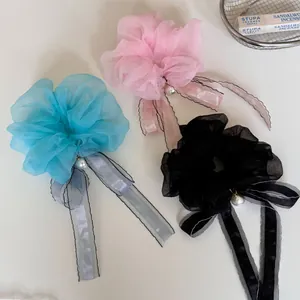 Close-up detail of elegant organza scrunchies with long ribbons and pearl charms